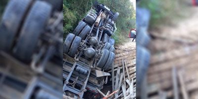 Caminhão carregado de toras capota em ponte no interior de Dom Feliciano