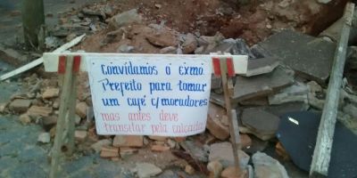 Com ironia, moradores afixam cartazes pela falta de manutenção de calçada na Boaventura Soares